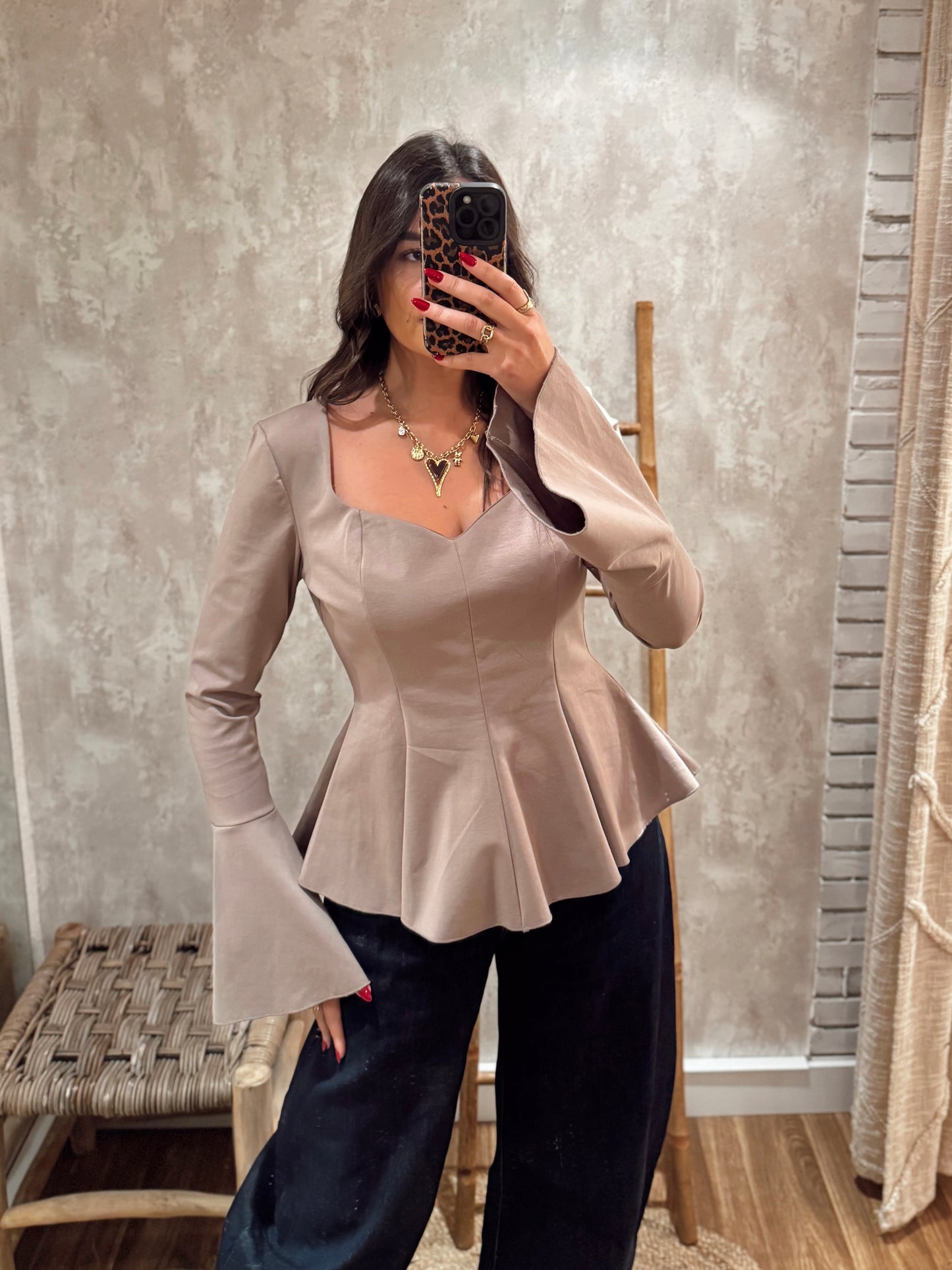 Blusa estruturada com efeito péplum e punhos folhados