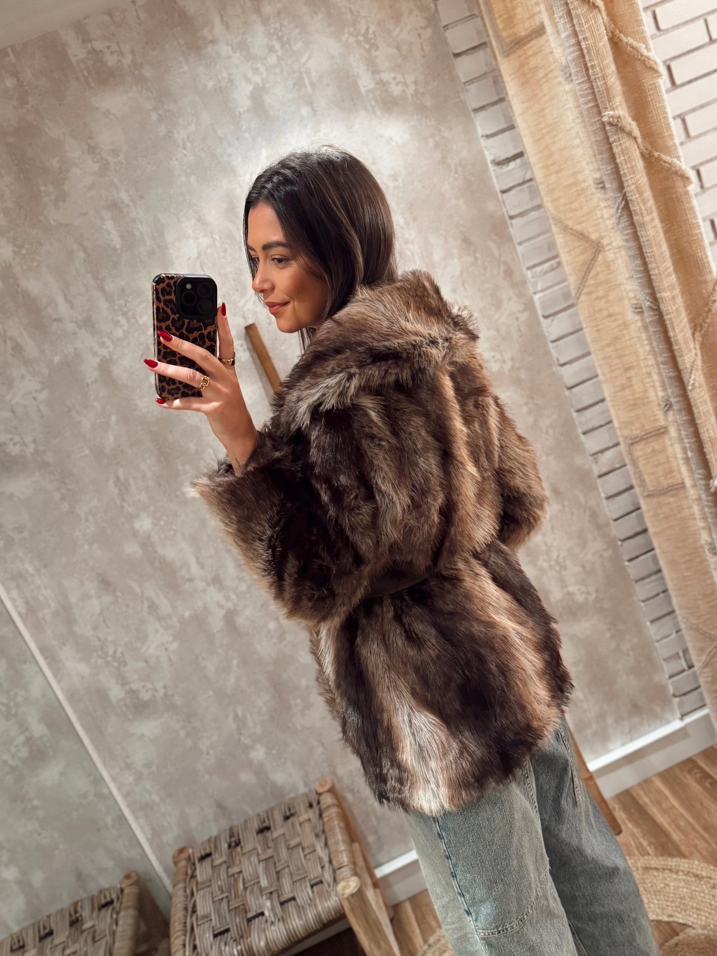 Casaco de pelo sintético em tons castanhos, com corte moderno e cinto para ajustar na cintura