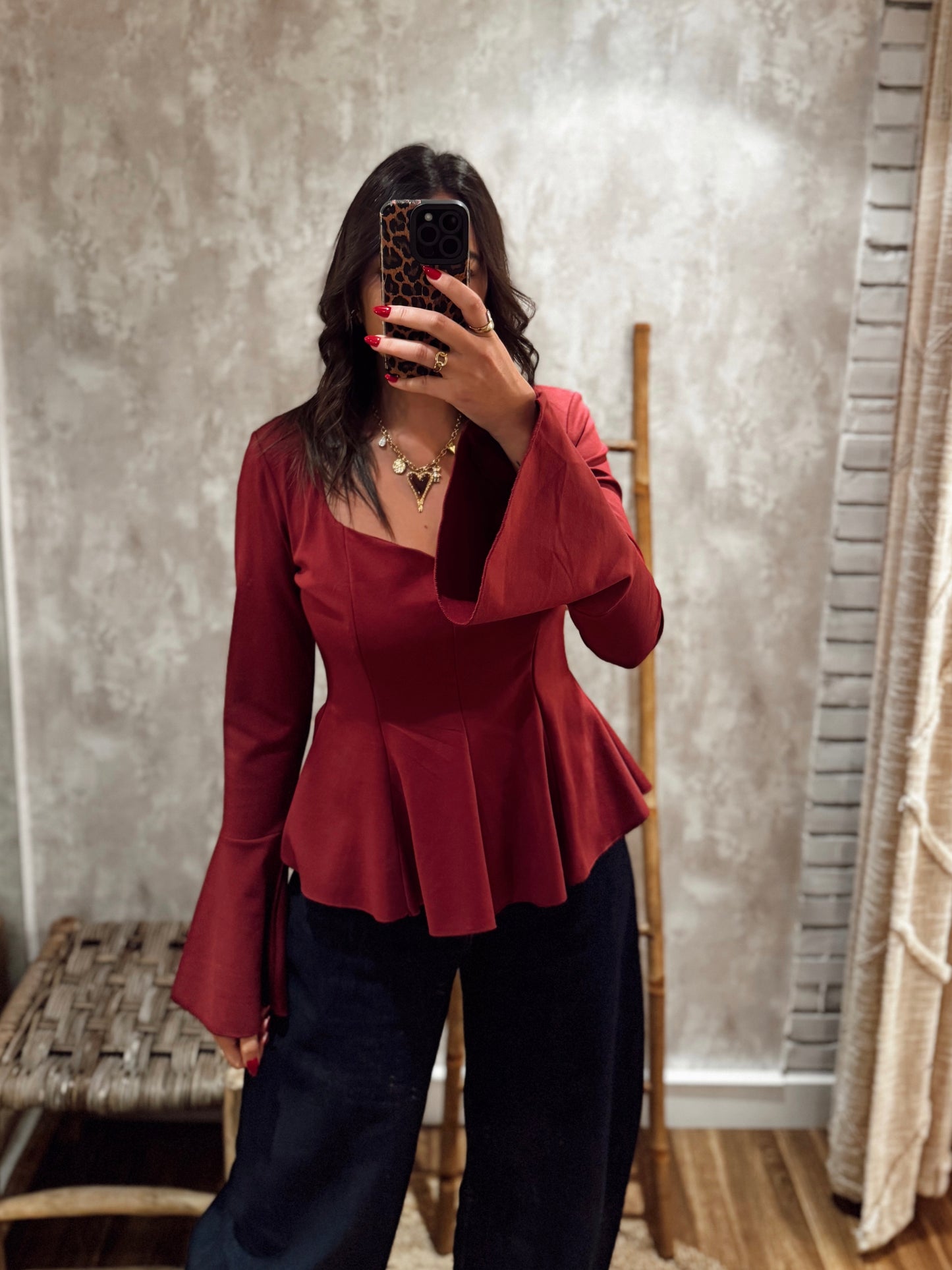 Blusa estruturada com efeito péplum e punhos folhados