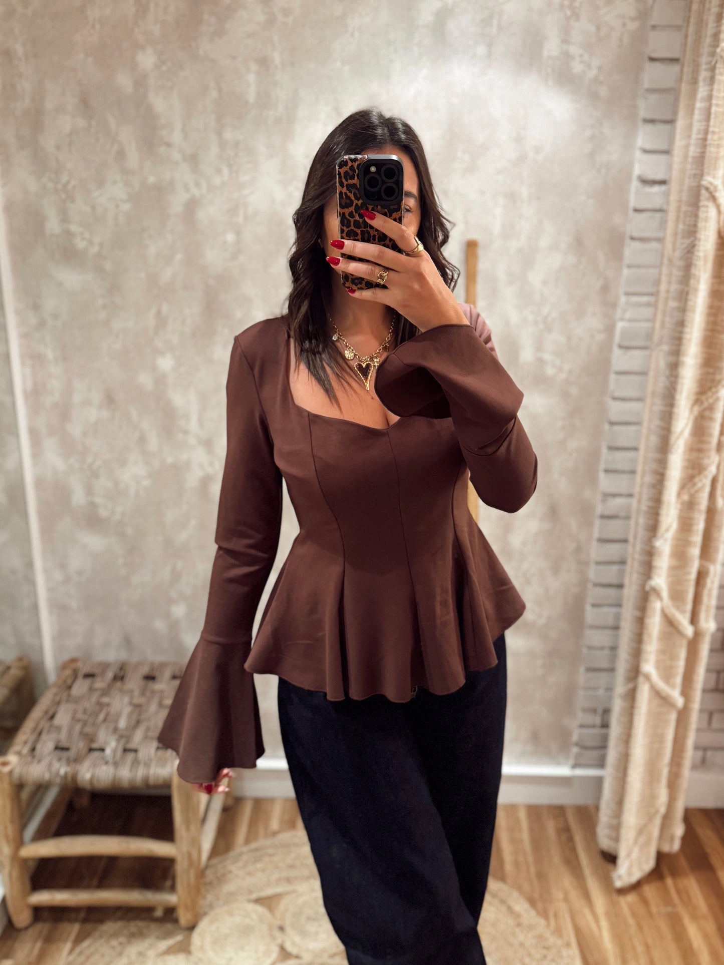 Blusa estruturada com efeito péplum e punhos folhados