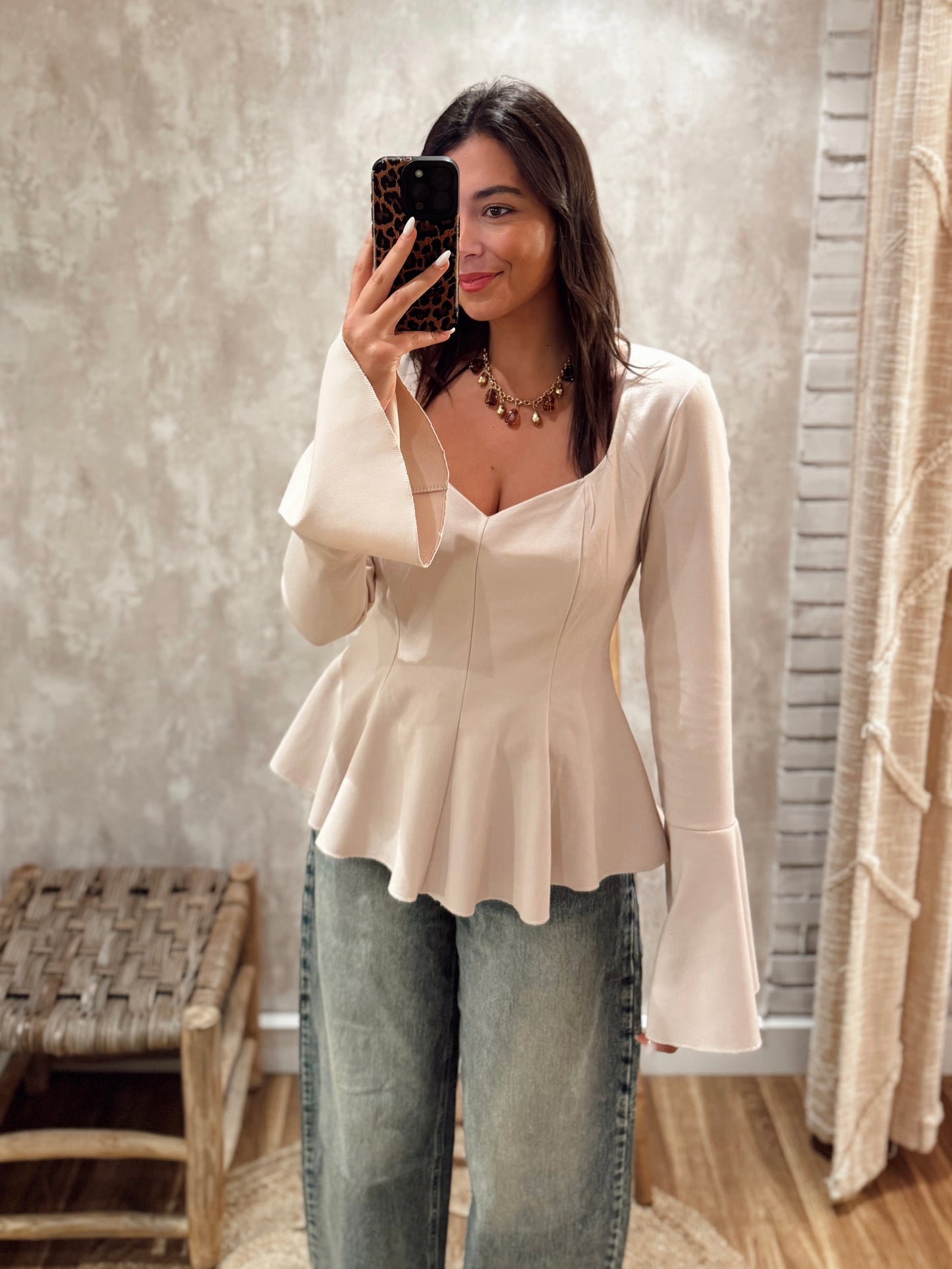 Blusa estruturada com efeito péplum e punhos folhados