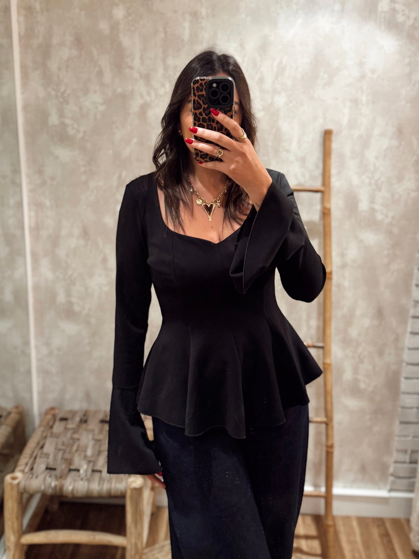 Blusa estruturada com efeito péplum e punhos folhados